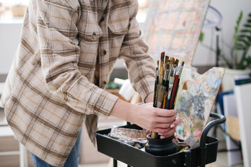 Paint-splattered brushes close up with oil paint in the art studio