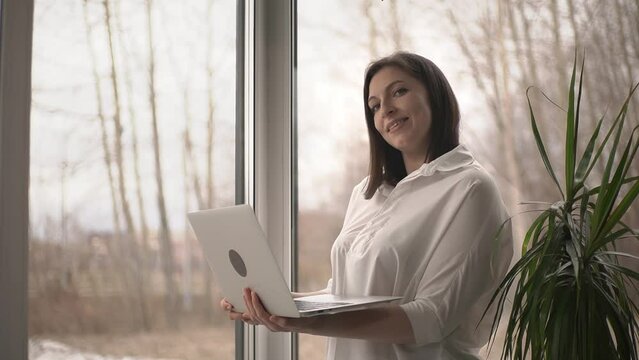recyclable materials. woman holding laptop.laptop and recyclables. slow motion video. High-quality shooting in 4K