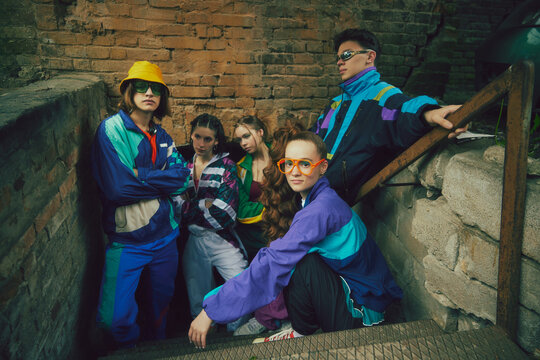 Urban outfit collection. Five young stylish people, boys and girls wearing vintage streetwear, vibrant windbreakers and athletic wear. Concept of 90s, fashion, youth culture, old-style trends