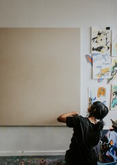 Woman artist painting on a big blank canvas