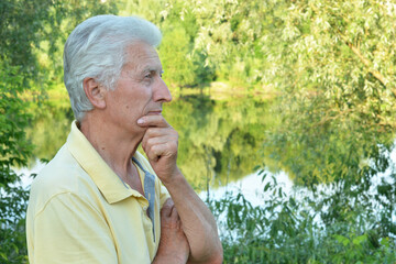 Close up portrait of thinking senior man in park