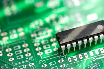DIP package IC microchip on a green printed circuit board.