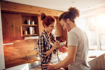 Happy couple embracing and kissing in sunny kitchen