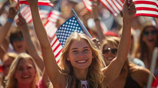 Young american woman smiling, holding American flags at outdoor event.