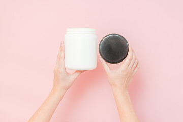 Hands hold white bottle with nourishing mask for applying to hair or skin. Beauty and spa, cosmetics