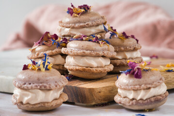  Stack of Macarons with Edible Flowers on wooden board