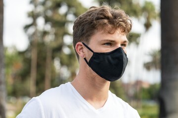 Man wearing face mask in park, the new normal lifestyle