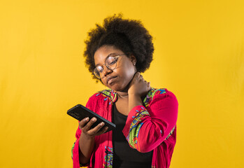 Una mujer afroamericana usando teléfono celular en la mano y disfrutando de aplicaciones sobre...