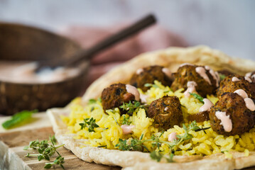  Crispy falafel balls served on a bed of yellow rice and naan bread