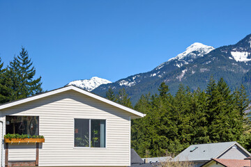 Top of average residential house with mountain view on blue sky background