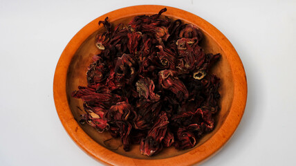 Dried roselle flowers on a wooden plate