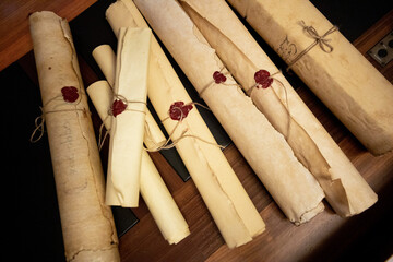 ancient parchments rolled up and held closed by a string and a red wax seal