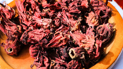 Dried roselle flowers on a wooden plate