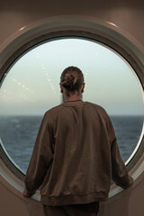 man looking out the ship's window