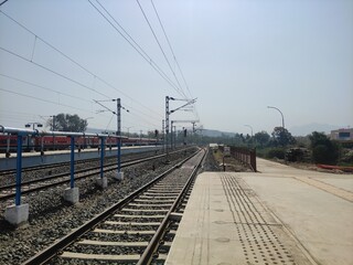 Fototapeta premium Rails leading to an empty train station; no one in sight.