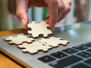 Jigsaw puzzle on laptop Connecting team success and marketing strategy ideas on internet technology