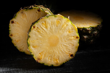 sliced pineapple on black wood background - 801203911