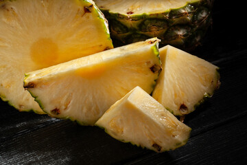 sliced pineapple on black wood background - 801203921