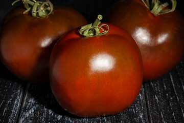 kumato tomato on black wood background - 801204779