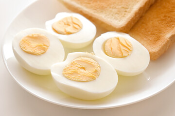 Boiled eggs with two slices of toast on a plate. 