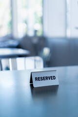 Reserved sign on coffee shop, cafe table with blurred background