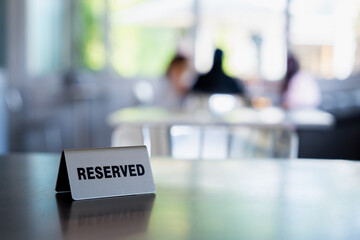 Reserved sign on coffee shop, cafe table with blurred background
