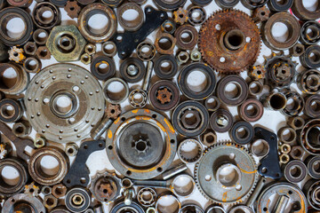 Obraz premium The old rusty car bearing texture background and old motorcycle parts lined up with Rusted metal car parts, and leftovers of a repairman on a white background.