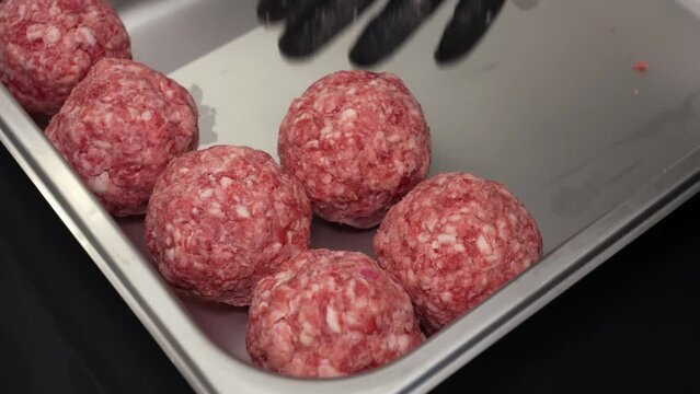A step-by-step process of preparing meatballs from fresh minced meat, showcasing the mixing, shaping, and ready for cooking stages.