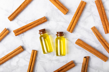 Cinnamon aromatic essential oil and cinnamon sticks on a wooden background. Aromatherapy. Organic cosmetic oil. Spa concept. Place for text. Copy space.