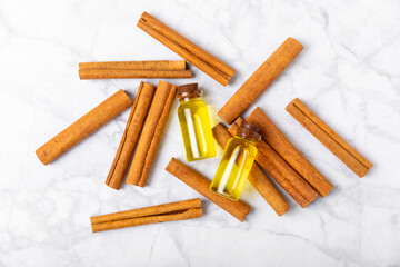 Cinnamon aromatic essential oil and cinnamon sticks on a wooden background. Aromatherapy. Organic cosmetic oil. Spa concept. Place for text. Copy space.
