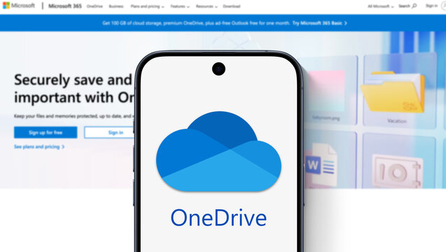 OneDrive logo displayed on a modern smartphone, website of the service behind it, hosting service, cloud backup, storage backend