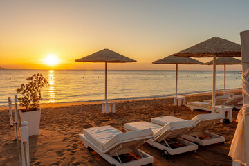 View of tropical beach with umbrelles during sunset. Holiday vacation and travel concept.