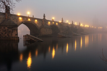 View of the Charles Bridge in Prague at the sunrise with mystical fog. Czech Republic.