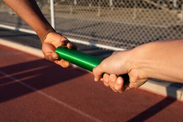 Team mate relaying the baton to another athlete