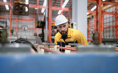 Industrial engineer in safety helmet uniform jacket working in heavy steel engineering factory....