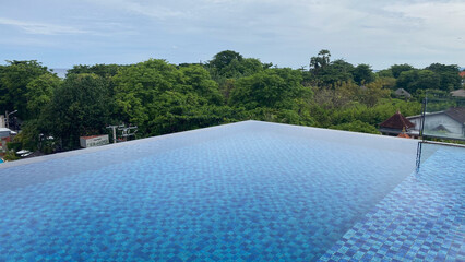 infinite swimming pool with a blue water and trees in the background in bali