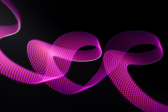 Pink and purple neon glowing wave of light as curls with dotted stripes on black background, pattern. Abstract background with motion light effect, light painting in disco party style. - Powered by Adobe