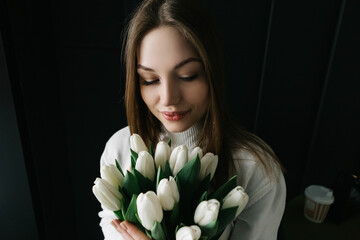 Young woman sitting in cafe with bouquet bunch of fresh spring tulips flowers, celebrating...