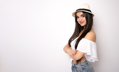 Young woman wearing straw hat with arms folded standing isolated over white background.