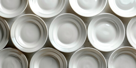 Minimalistic design of empty white plates arranged in stacks in a single order. A set of clean dishes. An aesthetic combination of white porcelain plates.