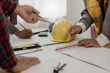 A diverse team of experts works on a real estate construction project with civil engineers,...