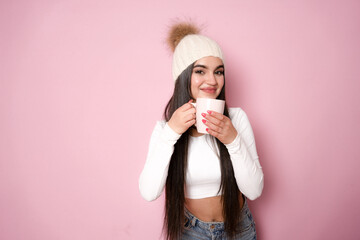 Young woman hold coffee mug smell aroma dressed stylish knitted winter hat isolated on pink color...