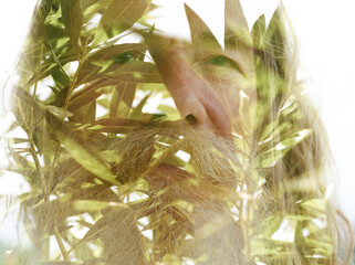 A closeup double exposure portrait of an old man merged with green tree leaves