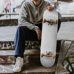 Man in gray hoodie sitting with white skateboard on steps © Rawpixel.com