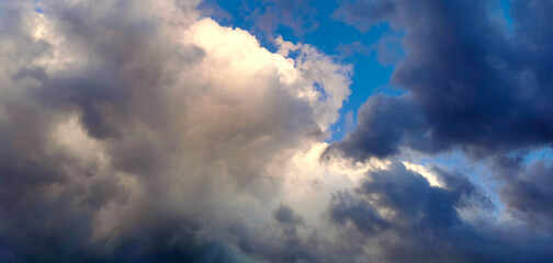 Grandi nuvole bianche e nere nel cielo azzurro - obrazy, fototapety, plakaty