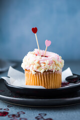 Cupcakes with cream cheese and strawberries. Cupcakes for valentine's day on a concrete table