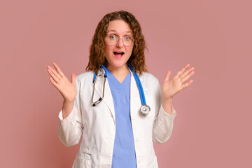 Enthusiastic female doctor, studio pink background. Nurse in uniform with stethoscope on red studio...