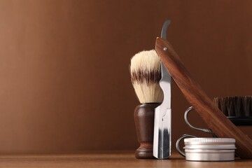 Moustache and beard styling tools on wooden table. Space for text