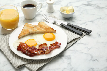 Delicious breakfast with sunny side up eggs served on white marble table. Space for text