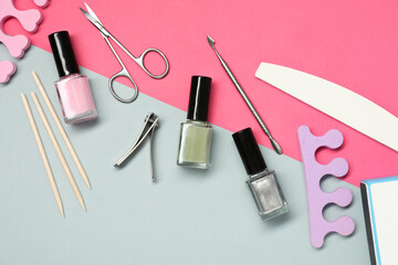 Nail polishes and set of pedicure tools on color background, flat lay - obrazy, fototapety, plakaty